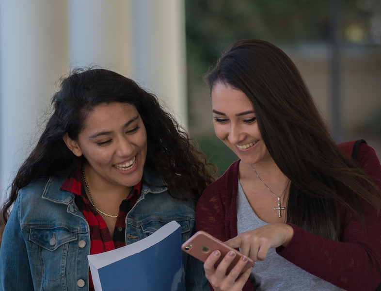 students pointing at phone