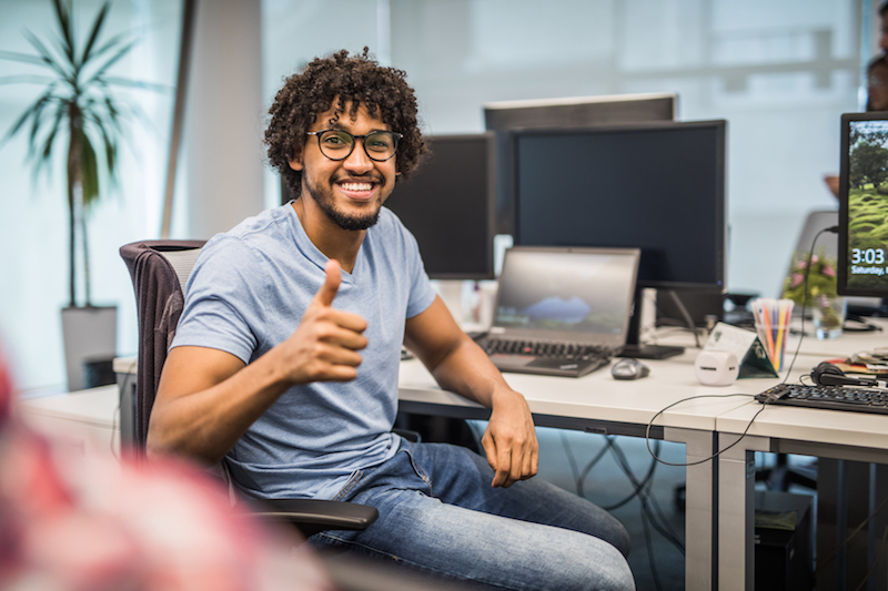 young man with thumbs up at computer