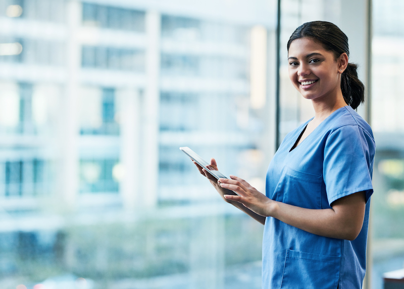 young woman in scrubs with tablet