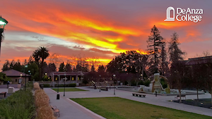 View of a bright orange sunrise above the Sunken Garden