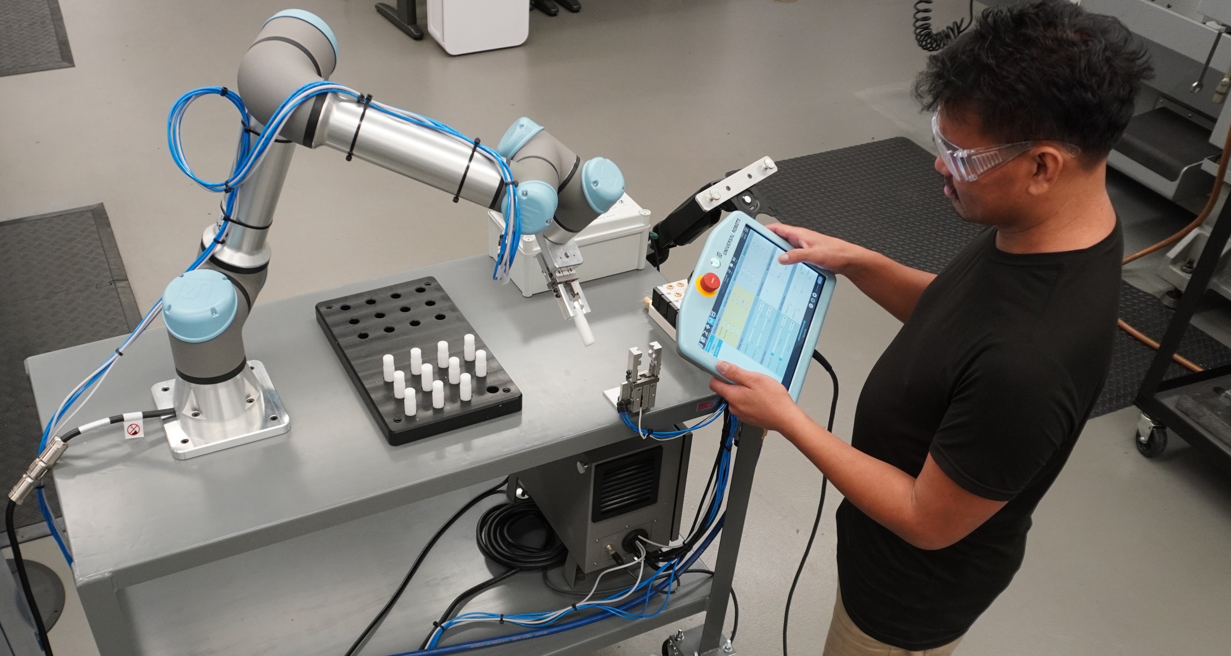 DMT male student programing robotic arm