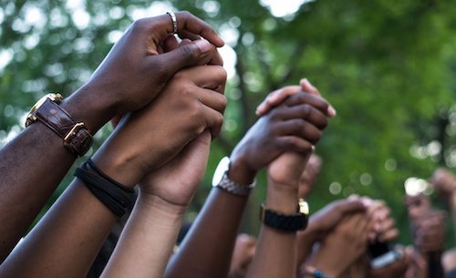 hands raised and clasped in unity