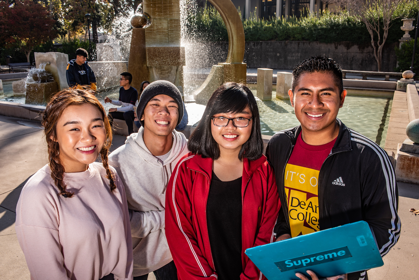 four students standing in front of Sunken Garden fountain