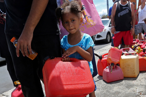 small girl waiting in line with water can