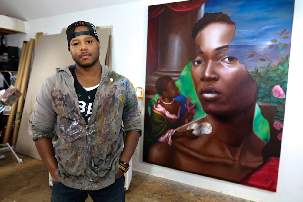 Artist Titus Kaphar stands in front of painting