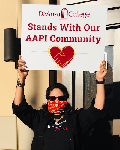 De Anza College student, instructor, administrators and staff with sign that says 