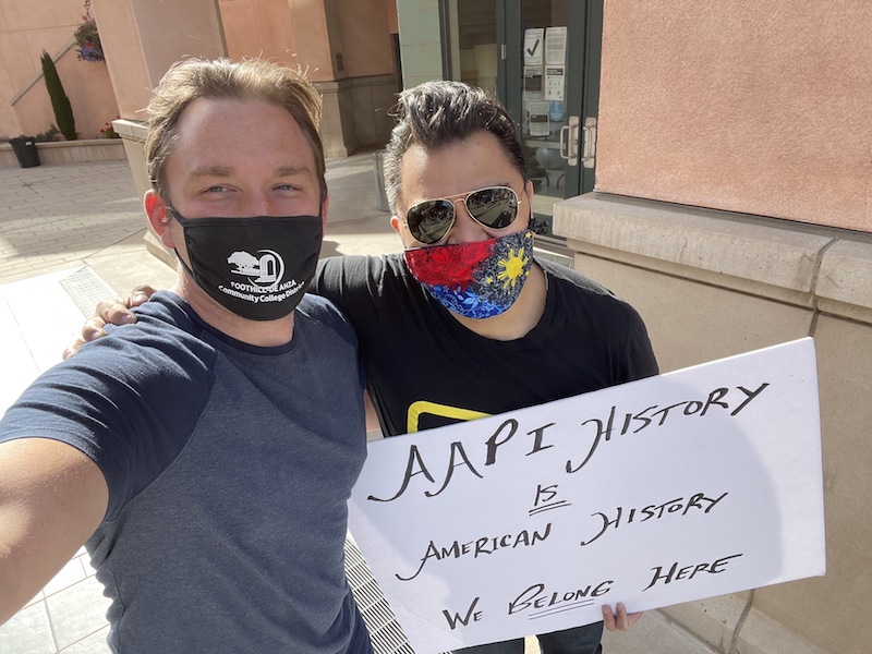 Two men with sign against racism