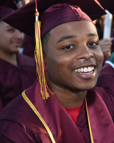 Young man in grad regalia with smile