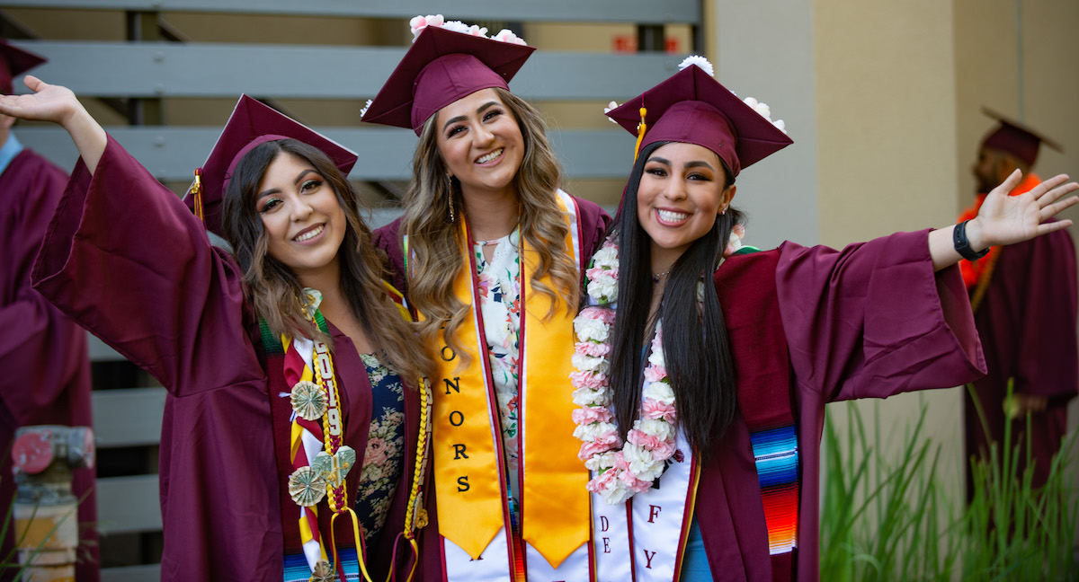 three young women in graduation regalia