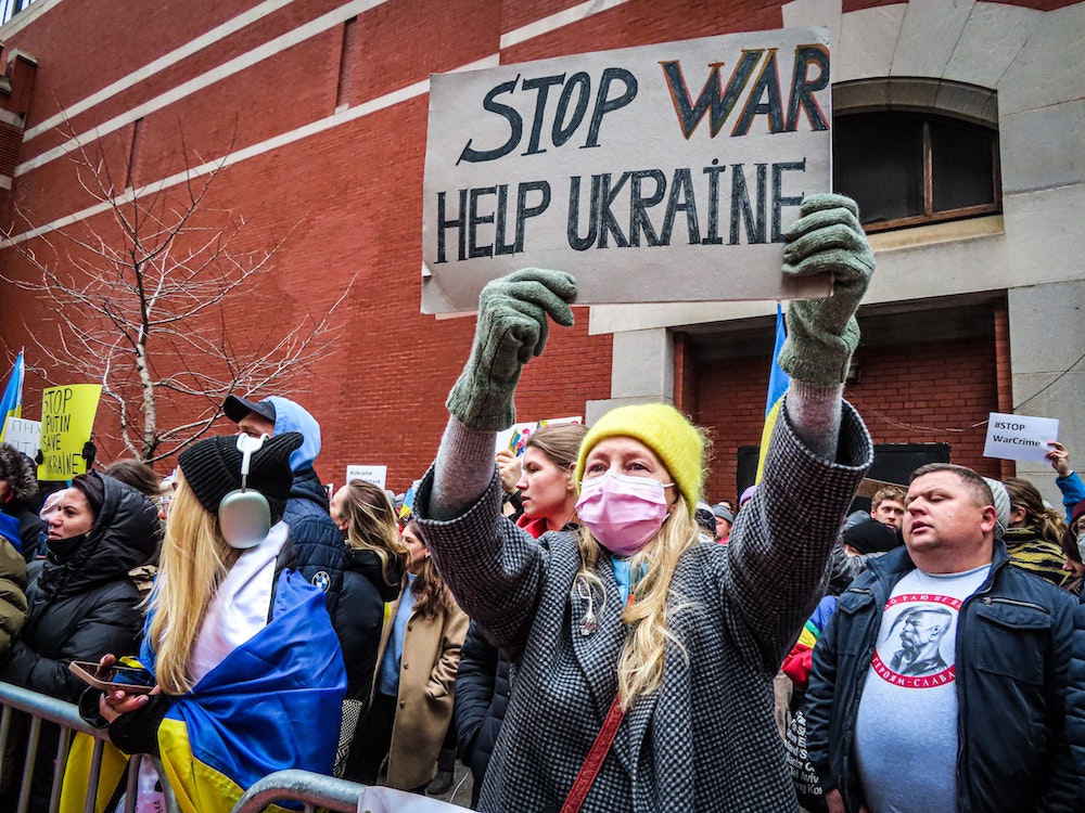 woman protester holding sign: Help Ukraine