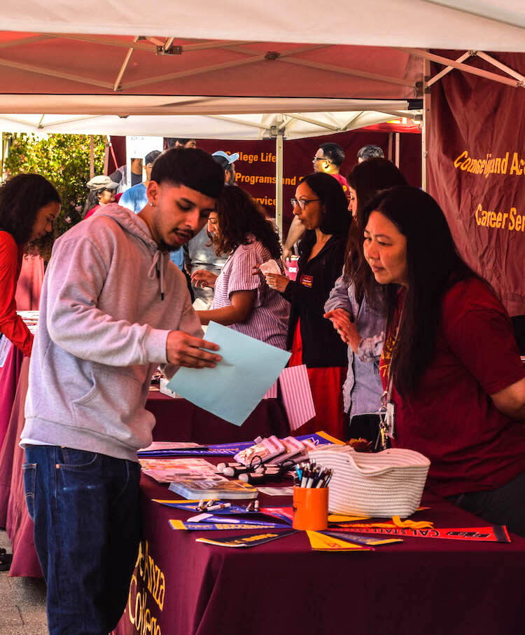 counselor answering student's question at Enrollment Day tent