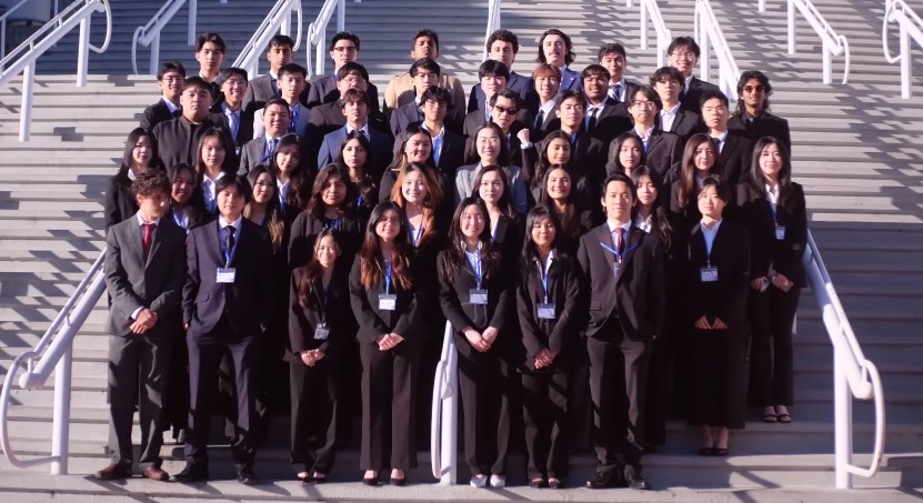 51 students in business suits, grouped on stairs