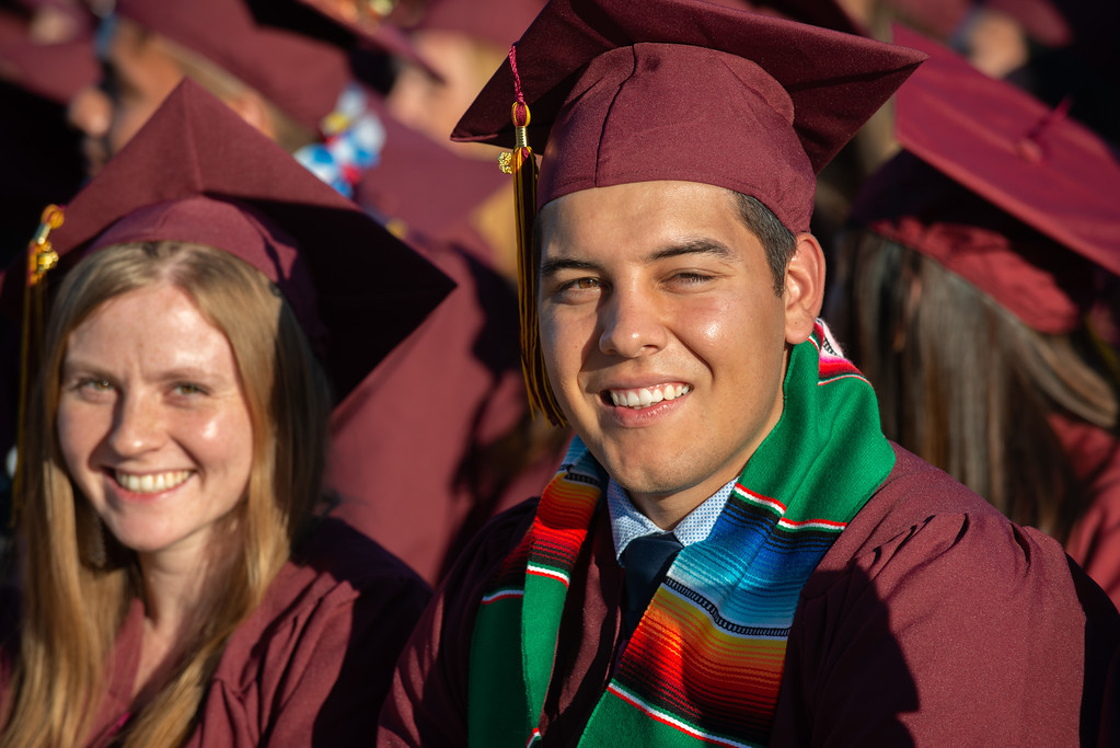 two smiling students in grad gear