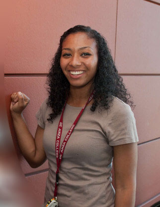 student standing by red wall