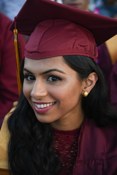 smiling young woman in grad cap and gown