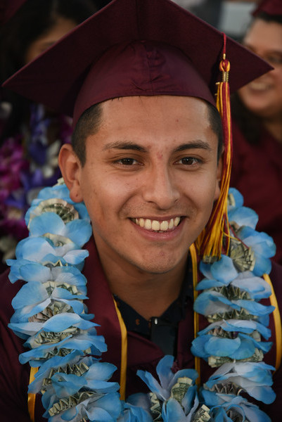smiling young  man in grad cap and flower lei