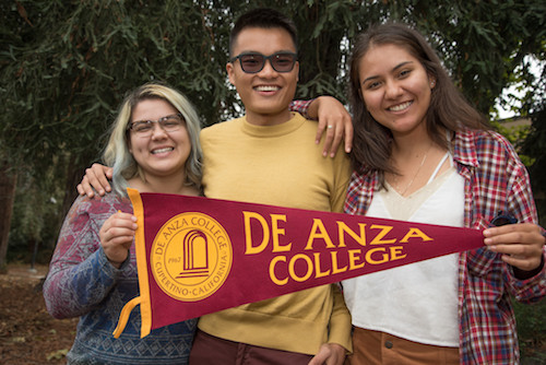 three students with De Anza pennant