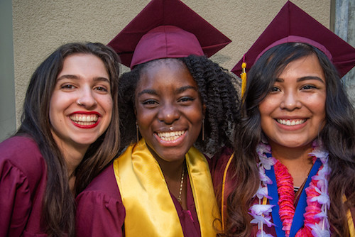 three grads smiling