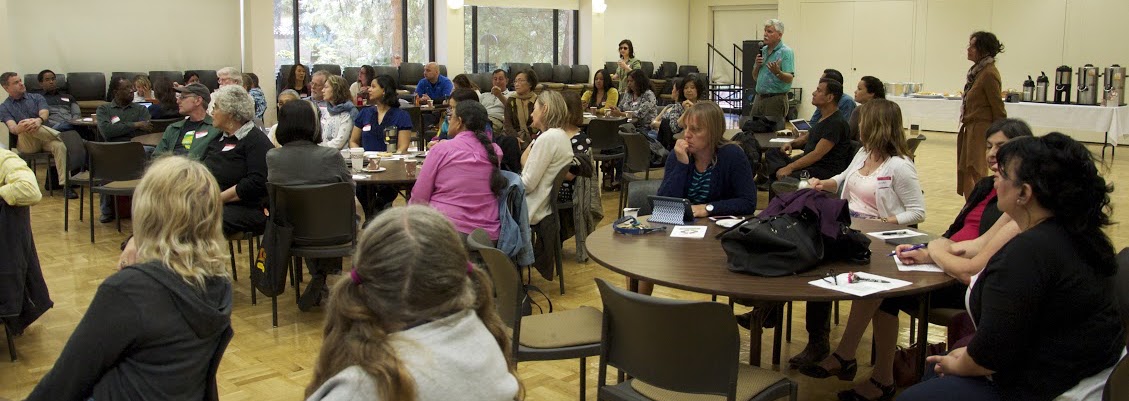 seated people listening to speaker in large room