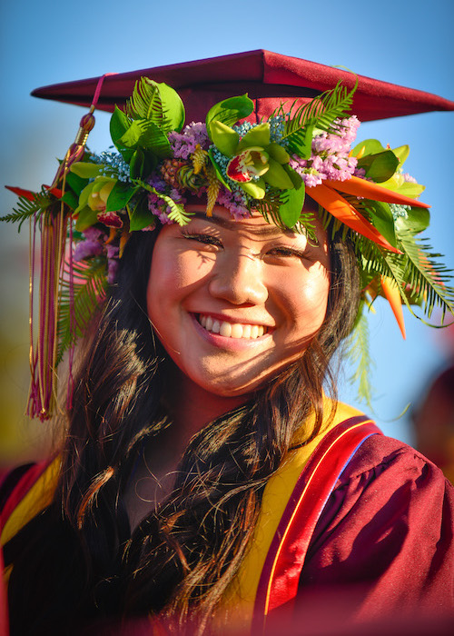 smiling young woman with grad cap and flower crown