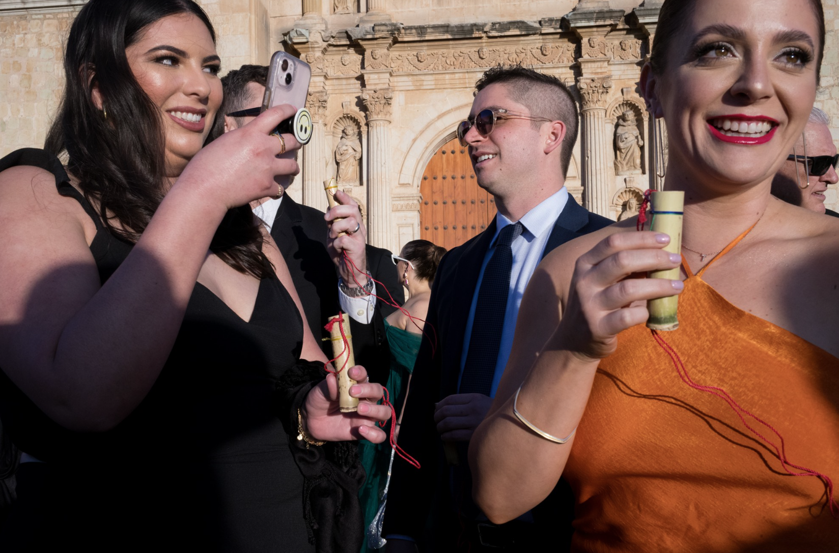 People in fancy clothes with smartphones and shot glass