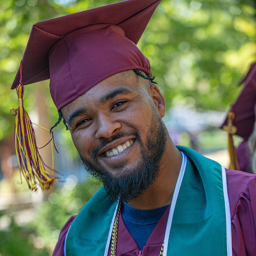 smiling young man in grad cap with head tilted