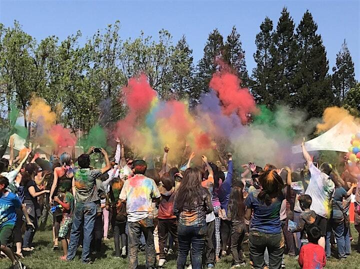 people celebrating Holi by throwing colored powders