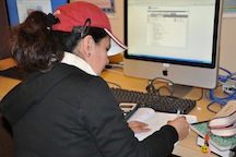 Female student with hat at a computer