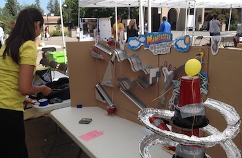 Female student demonstrating her physics obstacle course project.