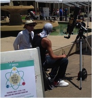 Male faculty and male student with solar telescope at math and science fair.