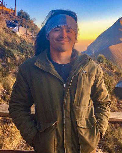 Juan Alas in civilian clothes in front of mountain