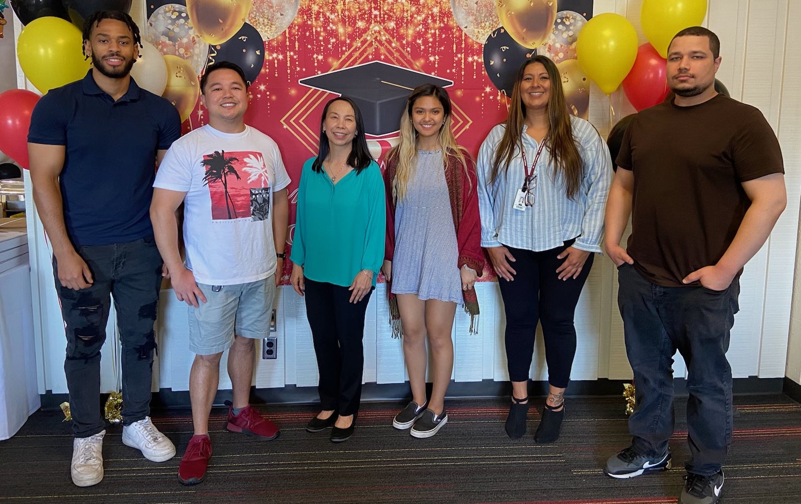 veteran students standing in front of graduation backdrops picture