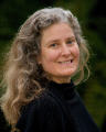 cynthia is outdoors looking at the camera with a green nature background